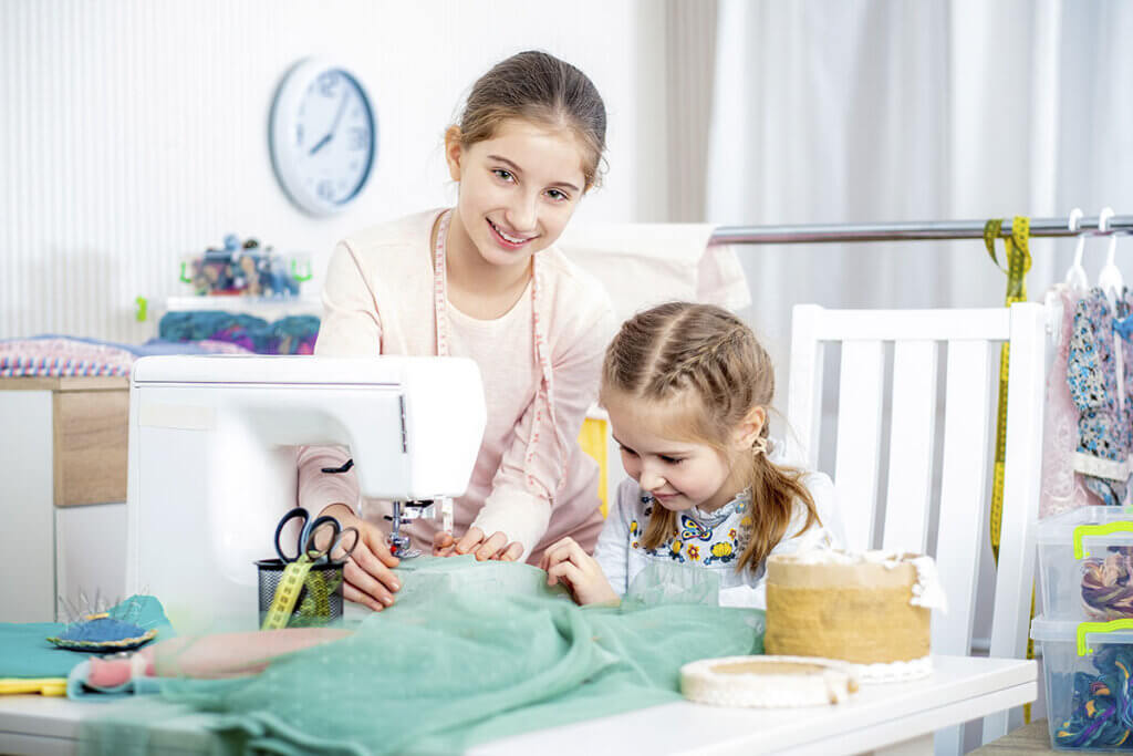 Siblings sewing with a children's sewing machine