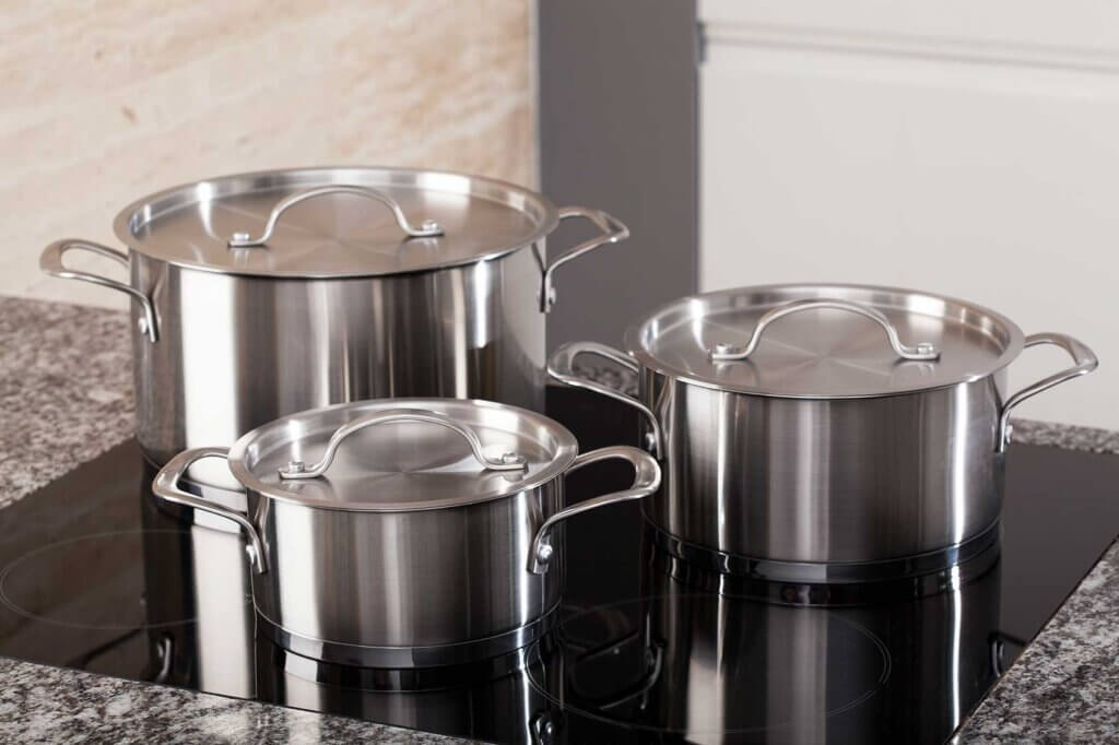 three pots standing on the stove in the kitchen