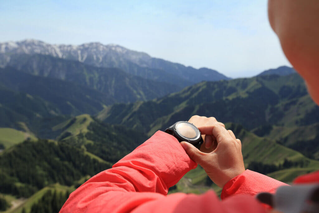Woman looking at watch while hiking