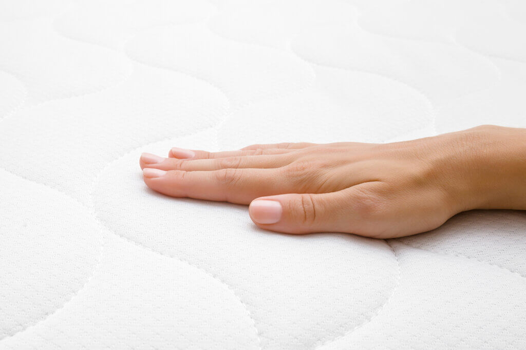 Hand lies flat on a mattress
