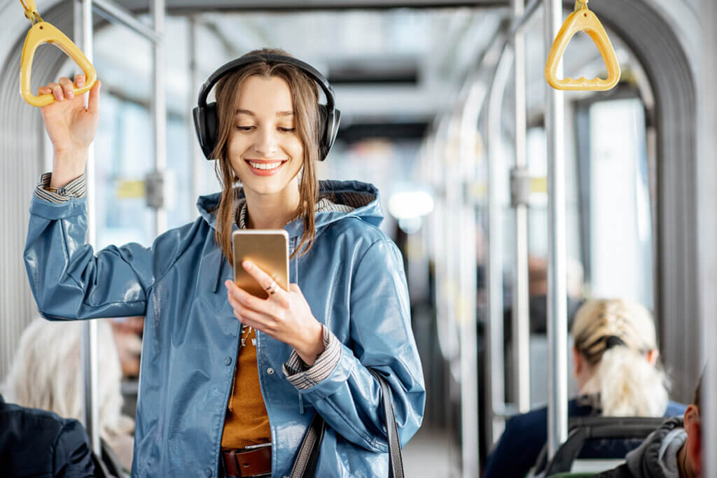 Young woman standing in the train with headphones on