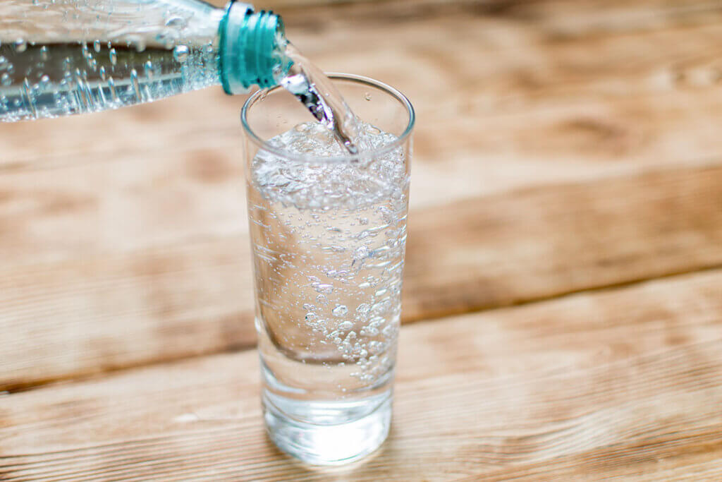 Sparkling water is poured into glass