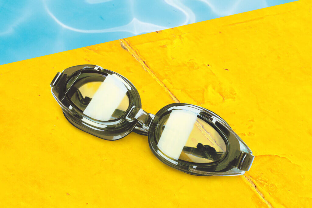 swim goggles on yellow pool rim