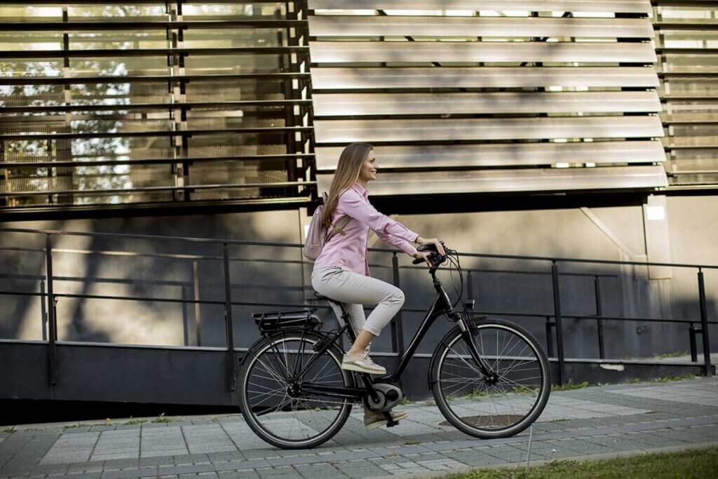  young woman on e-bike rides through the city
